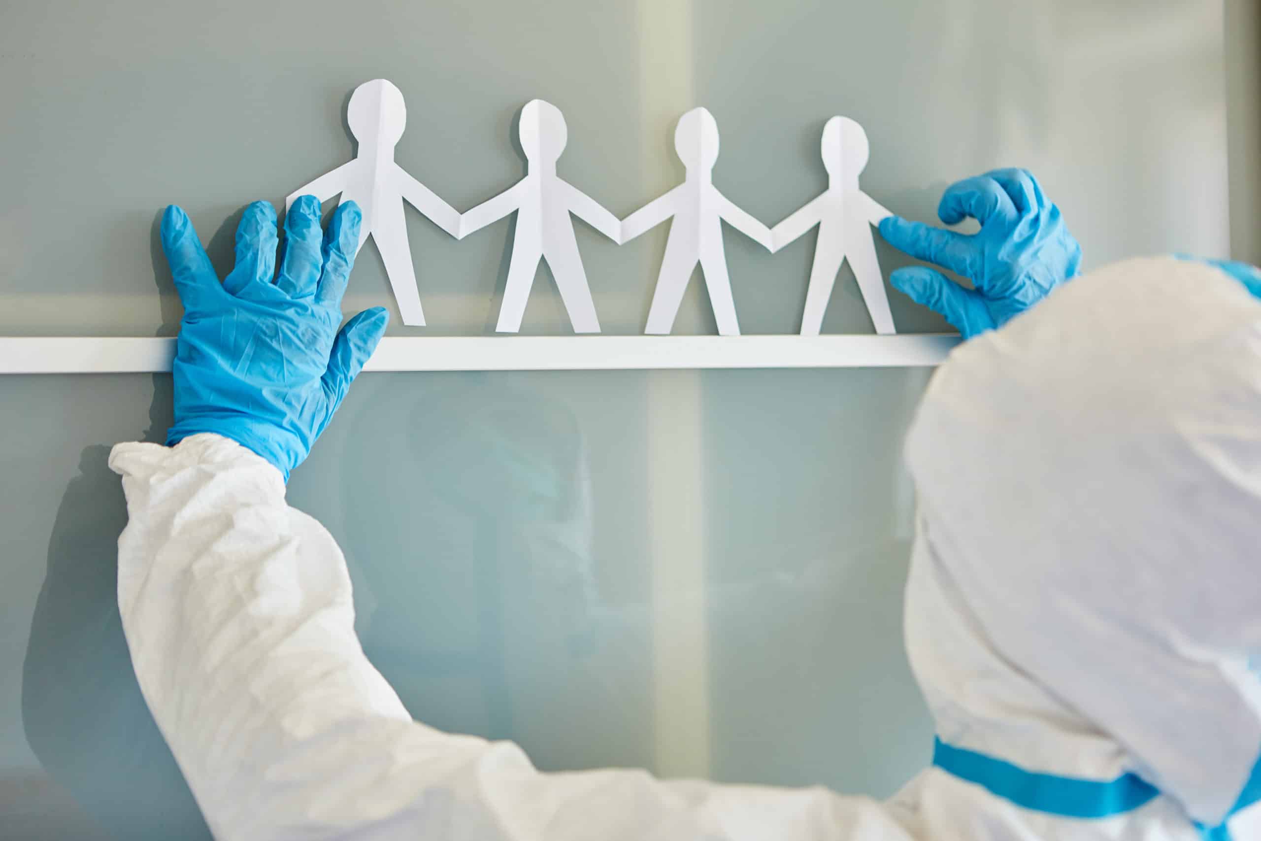 Eine Person im weißen Schutzanzug mit Papiermännchen, vermutlich in der Kommunalindustrie tätig, steht für Rohrreinigungsaufgaben bereit.