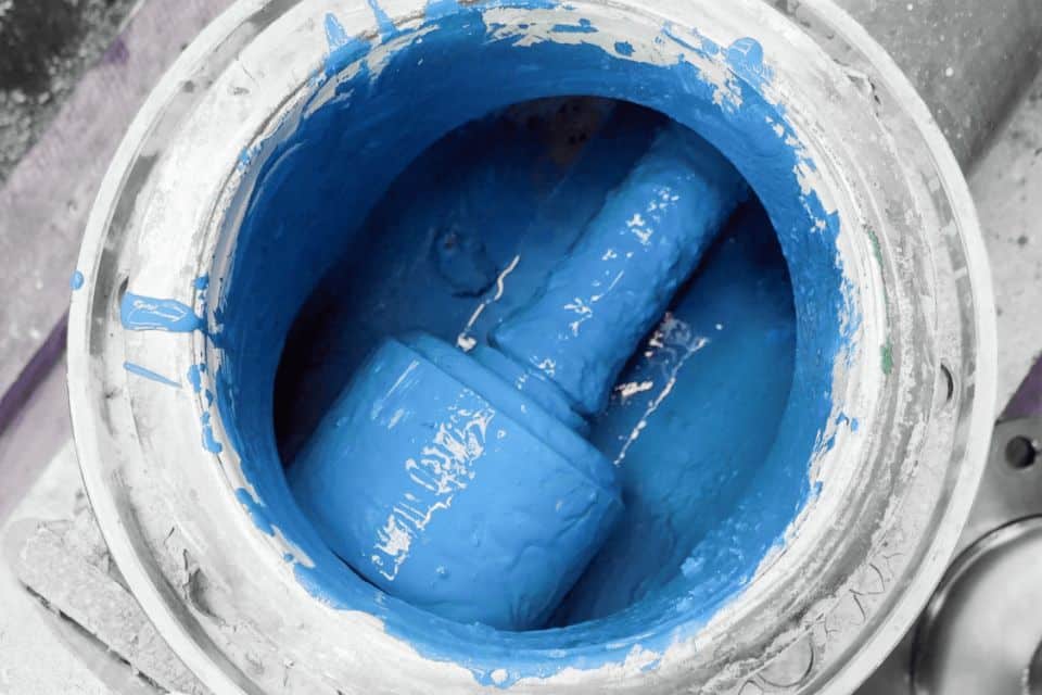 Ein Behälter gefüllt mit blauer Farbe und eine teilweise in die Farbe eingetauchte Farbrolle, bereit, jeder Oberfläche lebendige Impulse zu verleihen.